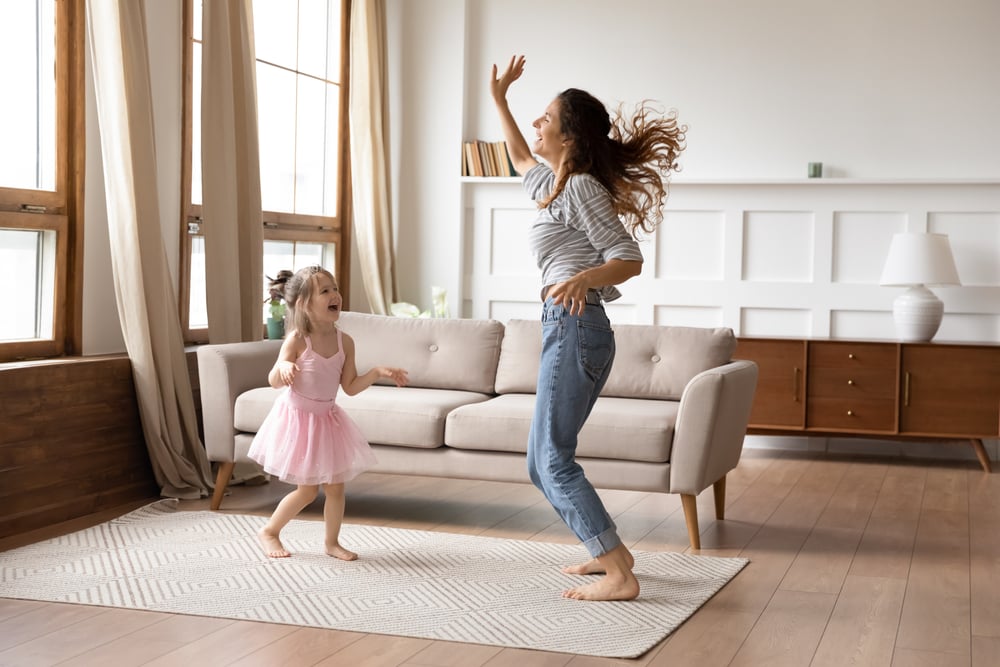 Mom and daughter dancing in a living room